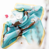 Scarf with cherry blossom design on a light blue background